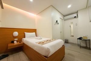 马尼拉Aurora Suites Pasay near Airport的房间里有一张大床的卧室
