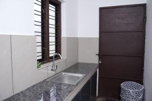 La cuisine est équipée d'un évier et d'un réfrigérateur noir. dans l'établissement Serene Cottage - Home away from Home, à Vythiri 25 autres photos