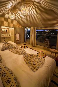 ein großes Bett in einem Zimmer mit Fenster in der Unterkunft Starlit Luxury Camp in Merzouga