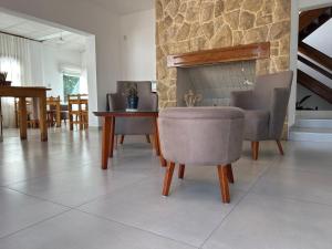 a living room with chairs and a table and a fireplace at Casa Piedra Hotel in Villa Carlos Paz
