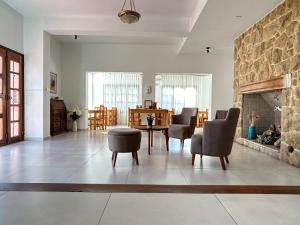 a living room with a fireplace and a table and chairs at Casa Piedra Hotel in Villa Carlos Paz
