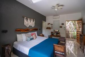 a bedroom with a blue and white bed and a window at Tamarindo Sunshine in Tamarindo