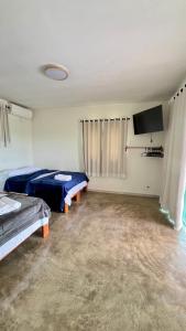 a bedroom with two beds and a flat screen tv at Vila Arcanjo in Santana do Riacho