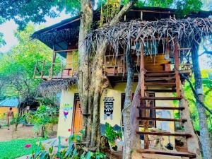 a tree house with a staircase leading up to it at Sigiriya Rastha 99 Hostel in Sigiriya