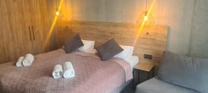 a bedroom with a bed with slippers on it at Czarna Perła Apartamenty Czarna Góra 203 in Sienna