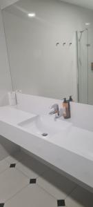 a white bathroom with a sink and a mirror at Czarna Perła Apartamenty Czarna Góra 203 in Sienna +10 photos