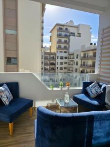 卡萨布兰卡apartment near the beach的客厅里有两把蓝色椅子和一张桌子