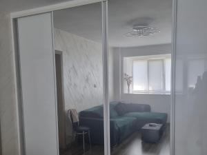 un soggiorno con divano verde e specchio di Ezzely apartment ParkLake a Bucarest