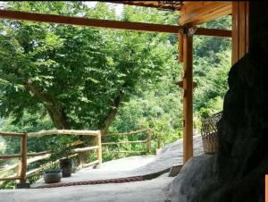 a view of a porch with a tree and a fence at Xiangtule Inn in Xinglong