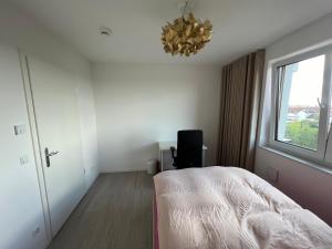 a bedroom with a bed and a window and a chandelier at Premium Room near S-Bahn Station in Berlin