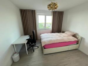 a bedroom with a bed and a desk and a window at Premium Room near S-Bahn Station in Berlin