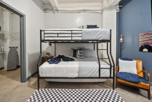 una camera con 2 letti a castello e una sedia di Retro Music Flat, 2BR, FREE Valet, Gym, Pool, Downtown Dallas a Dallas