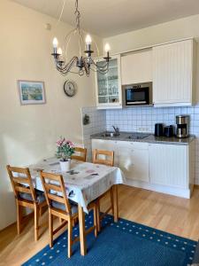 a kitchen and dining room with a table and chairs at Fürstenhof Ferienwohnung Grönland in Sassnitz