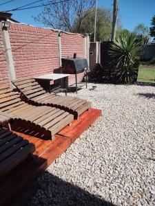 a patio with a bench and a table and a grill at quinta la peke in Ituzaingó