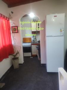 a kitchen with a white refrigerator in a room at quinta la peke in Ituzaingó