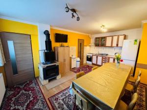 une cuisine avec une table et une cuisine aux murs jaunes dans l'établissement 2 Bungalowy Gitka pod Tatrami-malebná dedinka na hranici lesa TANAPu, à Mlynčeky