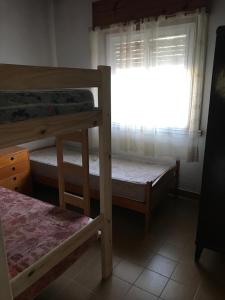 ein Schlafzimmer mit zwei Etagenbetten und einem Fenster in der Unterkunft Casa San Francisco in Mar del Tuyú