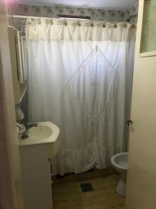ein Badezimmer mit einem weißen Duschvorhang und einem Waschbecken in der Unterkunft Casa San Francisco in Mar del Tuyú + 8 Fotos