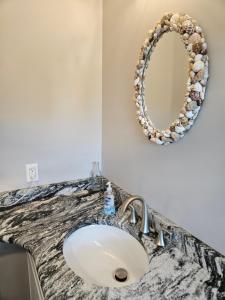 a bathroom counter with a sink and a mirror at Manatee River Bungalow in Bradenton +15 photos