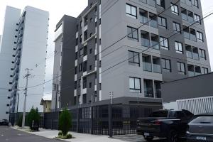 a tall building with cars parked in front of it at Tiwa Studio Requinte Amazônico Adrianópolis in Manaus