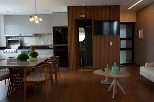 a kitchen and living room with a table and chairs at Tiwa Studio Requinte Amazônico Adrianópolis in Manaus