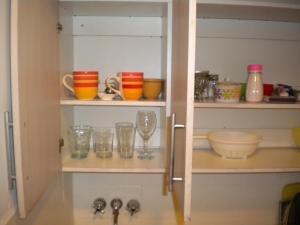 un armario lleno de vasos y cuencos en estanterías en Recoleta Apartamento en Buenos Aires