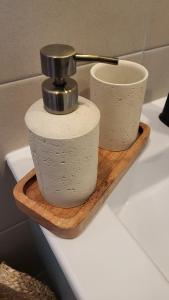 two cups on a wooden shelf with a faucet at Le Bas des Landes Gîte in Pléneuf-Val-André