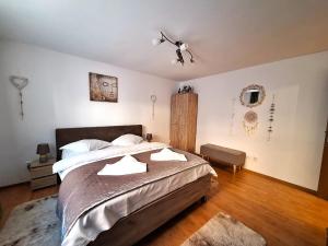 a bedroom with a large bed and a ceiling fan at Rustic Breeze Azuga - BBQ, Fireplace and Parking in Azuga