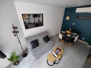 a living room with a couch and a table at Ateliers des rêves - climatisé, Dijon centre in Dijon