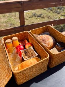 zwei Körbe mit verschiedenen Brotsorten und Früchten in der Unterkunft Secreto Sierras Domos Boutique con Jacuzzi y Desayuno in Aiguá