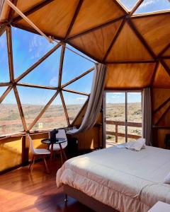 Zimmer mit einem Bett und einem großen Fenster in der Unterkunft Secreto Sierras Domos Boutique con Jacuzzi y Desayuno in Aiguá