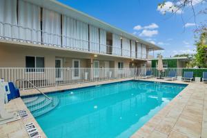 a swimming pool in front of a building at The Naples Beach Retreat in Naples