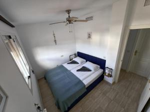 a bedroom with a blue bed and a ceiling fan at A & G Sabinillas in San Luis de Sabinillas