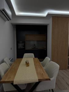 a dining room with a wooden table and white chairs at Luxury Apartmant Neptun Free Parking in Sarajevo