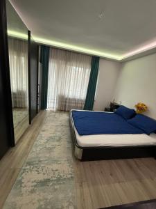 a bedroom with a bed with a blue comforter at Luxury Apartmant Neptun Free Parking in Sarajevo