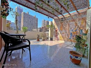 a patio with a chair and a table and potted plants at Lovely & Calm Rooftop in Maadi 5 min from the Nile in Cairo +47 photos