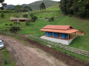 una piccola casa con un tetto rosso in un campo di Chalé alto valinhos a Itamonte
