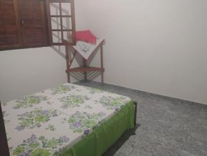 una camera da letto con un letto con una coperta verde e bianca di Chalé alto valinhos a Itamonte