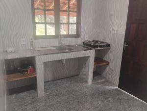 a bathroom with a sink and a window at Chalé alto valinhos in Itamonte +4 photos