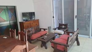 a living room with wooden furniture and a television at Bosquesito in Mina Clavero
