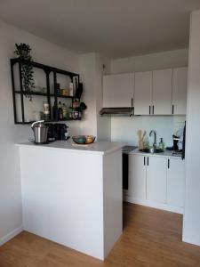 una cucina con mobili bianchi e un piano di lavoro di Les voiliers a Courseulles-sur-Mer