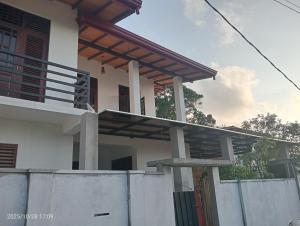 a house with a balcony and a fence at Angel home villa in Dickwella