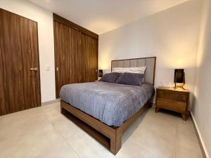 a bedroom with a bed and a night stand with a lamp at Modern Luxury Residency at Altea-Sunset Pool View in Puerto Vallarta +54 photos