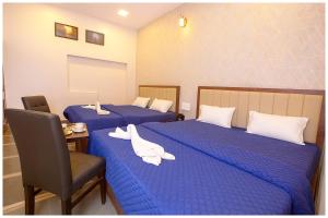 - une chambre d'hôtel avec 2 lits et des serviettes blanches dans l'établissement Hotel VM Char Palace Dham Near vishwanath temple # Free Parking # free Wifi - Best Premium Hotel, à Varanasi