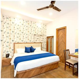 une chambre avec un lit et un bureau avec une chaise dans l'établissement Hotel VM Char Palace Dham Near vishwanath temple # Free Parking # free Wifi - Best Premium Hotel, à Varanasi