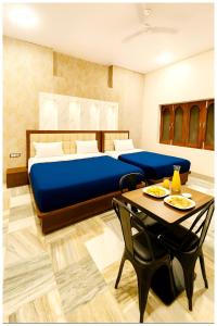 une chambre avec un lit et une table avec des chaises dans l'établissement Hotel VM Char Palace Dham Near vishwanath temple # Free Parking # free Wifi - Best Premium Hotel, à Varanasi