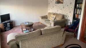 a living room with two couches and a tv at OakHouse- Entire 3 Bedroom Terrace House with Free Parking in Cumbernauld
