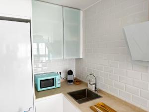 a kitchen with a sink and a microwave on a counter at BeniforniaLove in Benicàssim