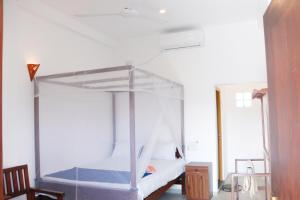 a bedroom with a white bunk bed in a room at Shehara Sun Surf Lodge in Midigama