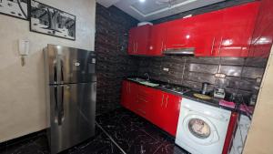 a kitchen with red cabinets and a washing machine at Tayyurt Apartement city centre agadir in Agadir
